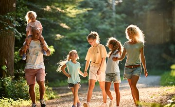 Lachende Familie mit Kindern im Wald