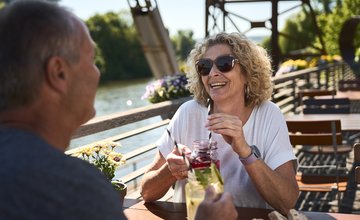 Paar sitzt am Fluss im Biergarten 